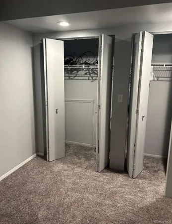 an empty room with closet and windows