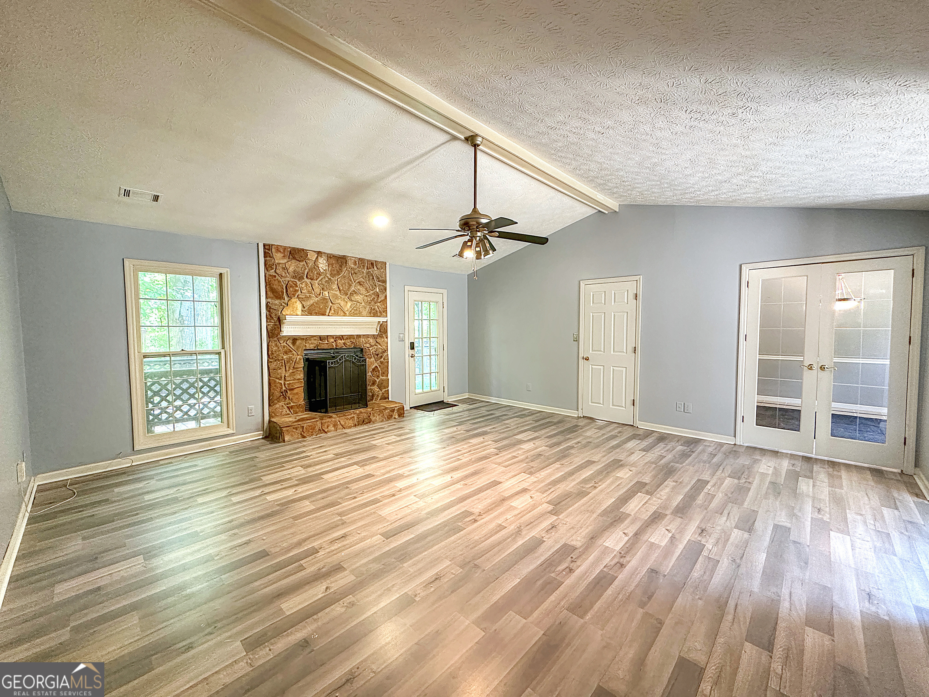 112 Greenbriar Trail LaGrange, GA 30241 - Photo 4 of 29 an empty room with wooden floor fireplace and windows