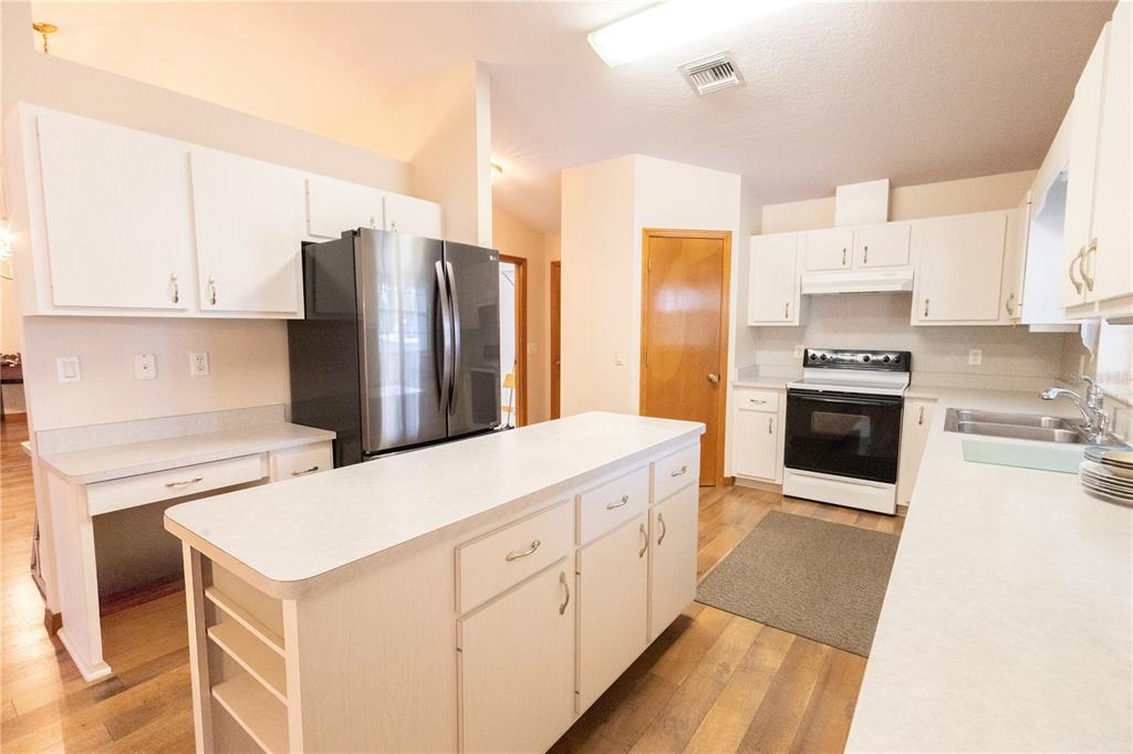 12681 Southeast 54th Avenue Belleview, FL 34420 - Photo 17 of 46 a kitchen with stainless steel appliances a stove refrigerator sink and cabinets