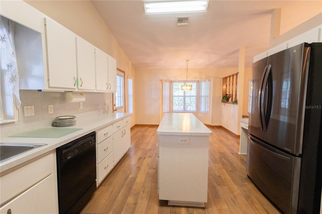 12681 Southeast 54th Avenue Belleview, FL 34420 - Photo 19 of 46 a kitchen with a refrigerator sink and white cabinets