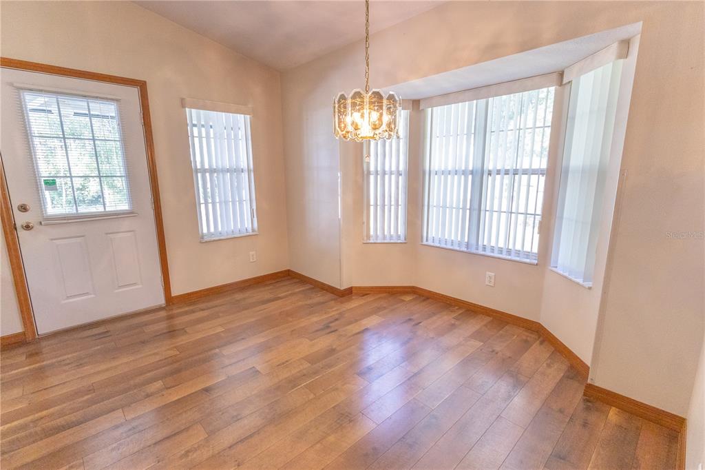 12681 Southeast 54th Avenue Belleview, FL 34420 - Photo 22 of 46 a view of an empty room with wooden floor and a window
