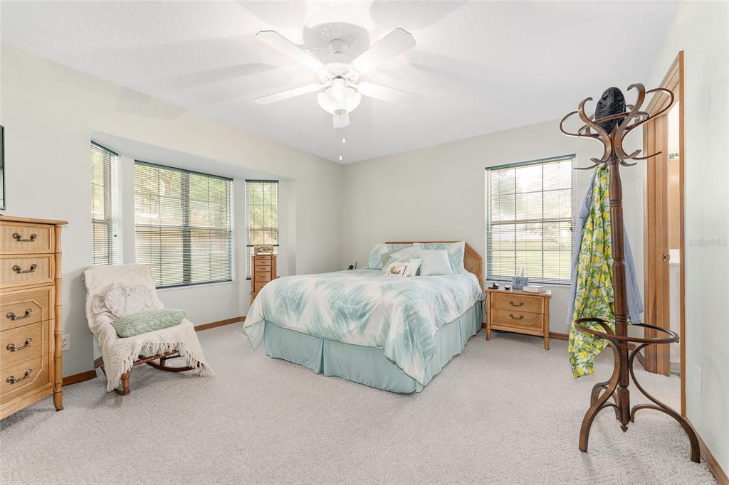 12681 Southeast 54th Avenue Belleview, FL 34420 - Photo 27 of 46 a spacious bedroom with a bed and a chandelier
