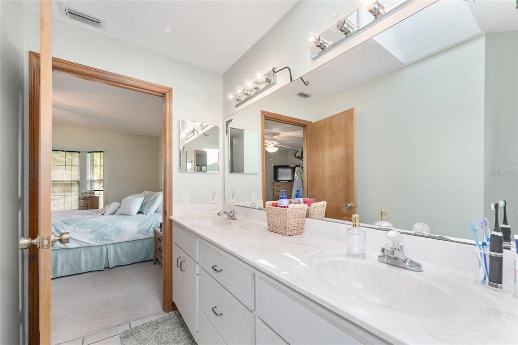 12681 Southeast 54th Avenue Belleview, FL 34420 - Photo 28 of 46 a en suite bathroom with double vanity sinks and a mirror