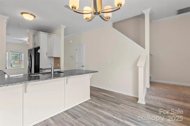 a view of a kitchen with kitchen island a sink appliances and cabinets