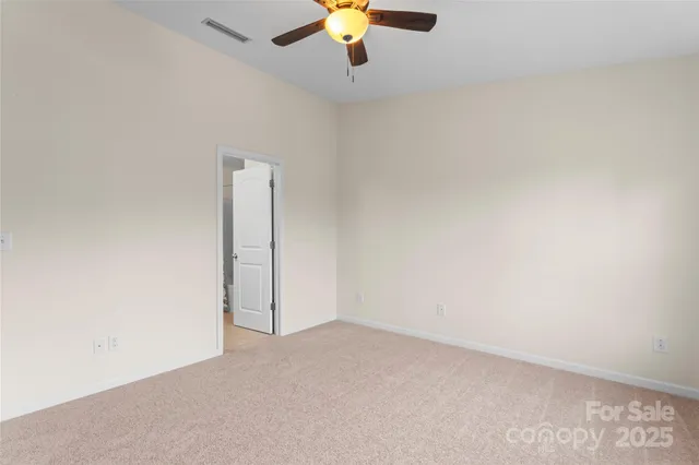 an empty room with a ceiling fan and window