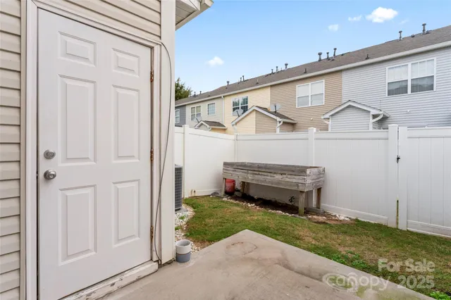 a view of a house with a small yard and a wooden bench
