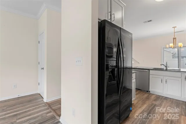 a kitchen with a refrigerator and white cabinets