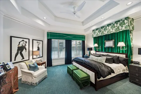 a bedroom with a bed couch and large window