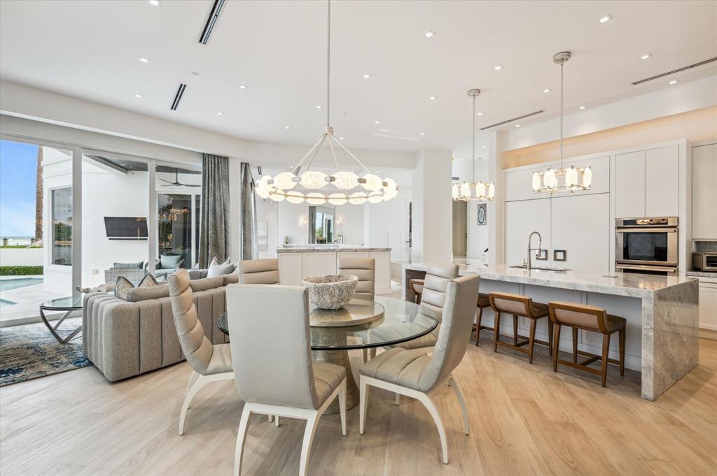 2400 Bay Drive Pompano Beach, FL 33062 - Photo 26 of 55 a dining room with furniture a chandelier and wooden floor