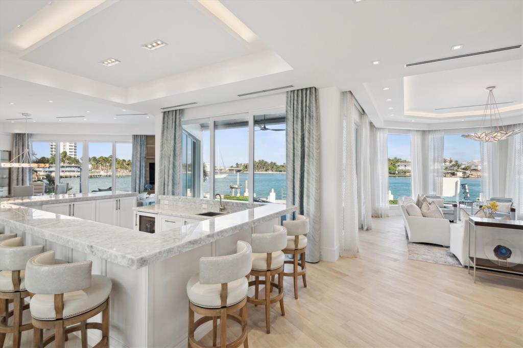 2400 Bay Drive Pompano Beach, FL 33062 - Photo 7 of 55 a dining hall with stainless steel appliances kitchen island granite countertop a living room view living room and couches with wooden floor