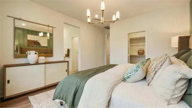 a bedroom with a large bed and a chandelier