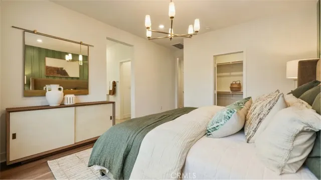 a bedroom with a large bed and a chandelier