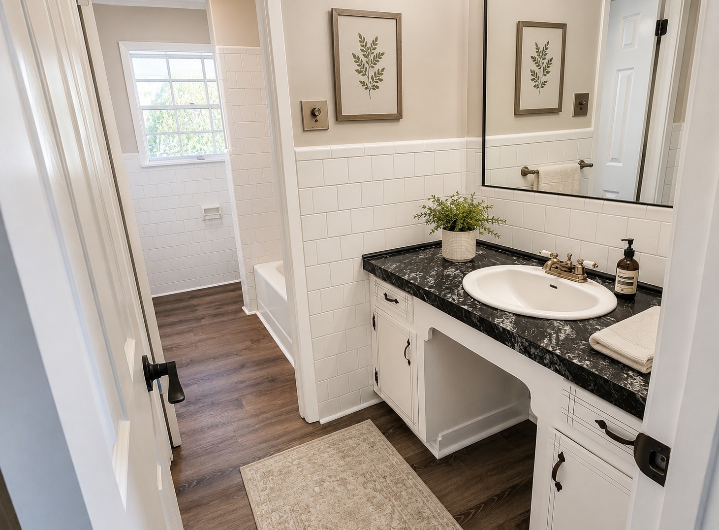 201 Verna Street Jasper, TX 75951 - Photo 16 of 24 This bathroom features a sleek black countertop with a white sink, surrounded by classic white tile backsplash. It includes a bathtub and has wood-style flooring, creating a clean and inviting space.