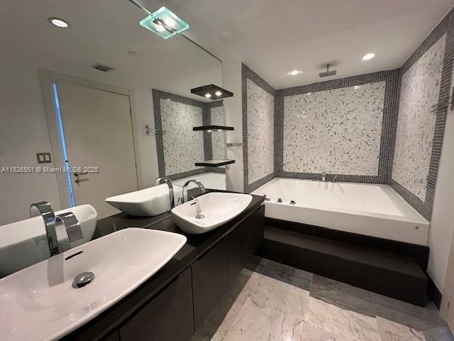 200 Biscayne Blvd Way, Unit 701 Miami, FL 33131 - Photo 11 of 12 a bathroom with a tub sink and mirror