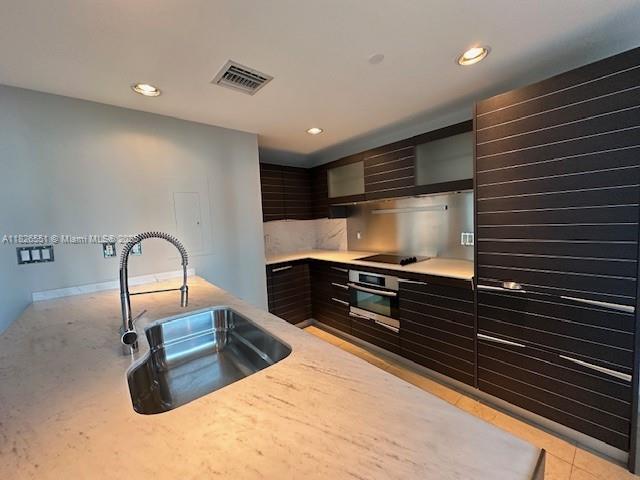 200 Biscayne Blvd Way, Unit 701 Miami, FL 33131 - Photo 6 of 12 a kitchen with kitchen island a sink stainless steel appliances and cabinets