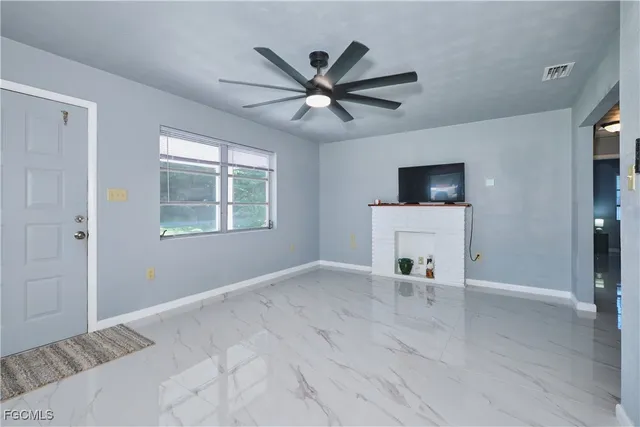 a view of an empty room with window and wooden floor