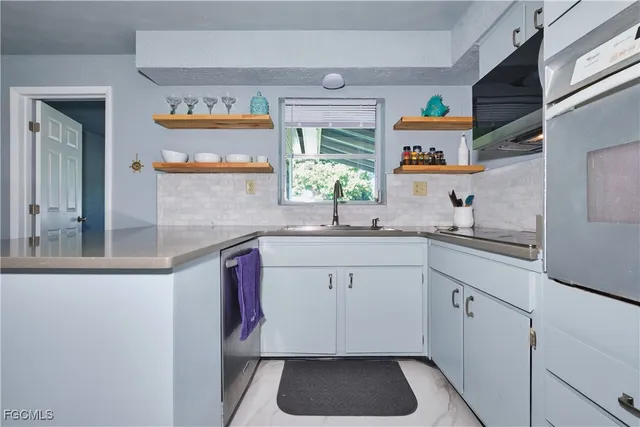 a kitchen with stainless steel appliances granite countertop a sink and a stove