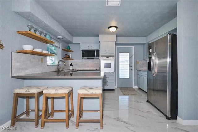 a kitchen with stainless steel appliances granite countertop a sink and refrigerator