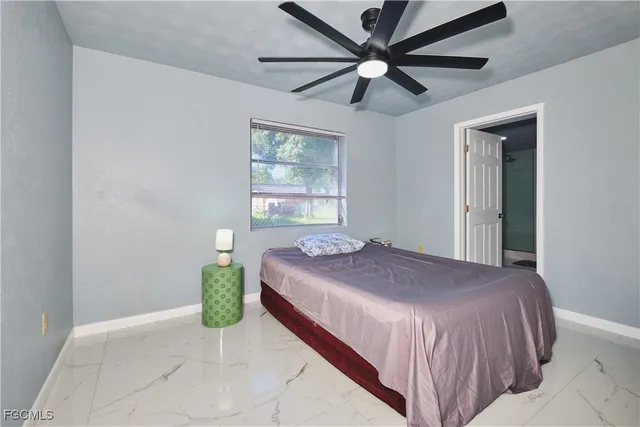 a bedroom with a bed and a ceiling fan