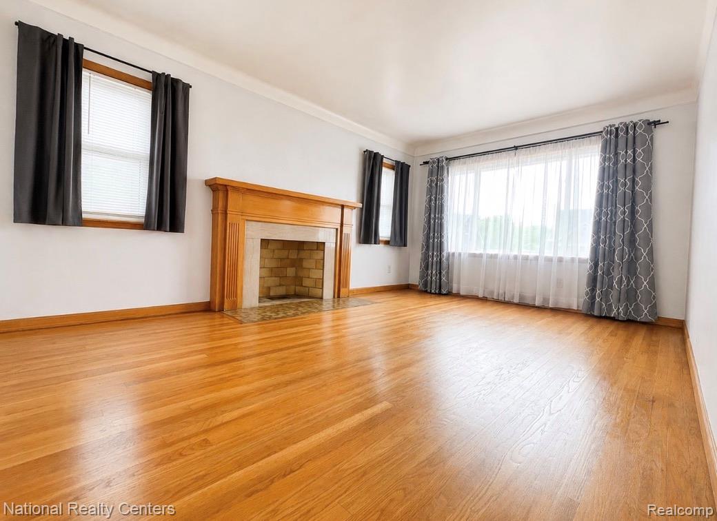 7285 Helen Street Center Line, MI 48015 - Photo 7 of 32 Spacious interior room featuring wood-finish flooring, a wood mantel, a brick-lined fireplace, and multiple windows