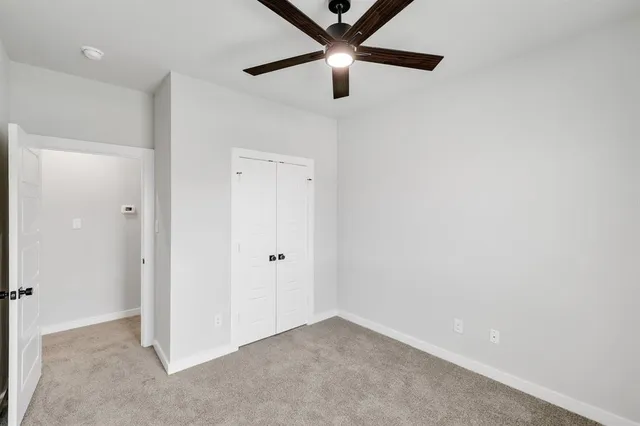 a view of an empty room with a ceiling fan