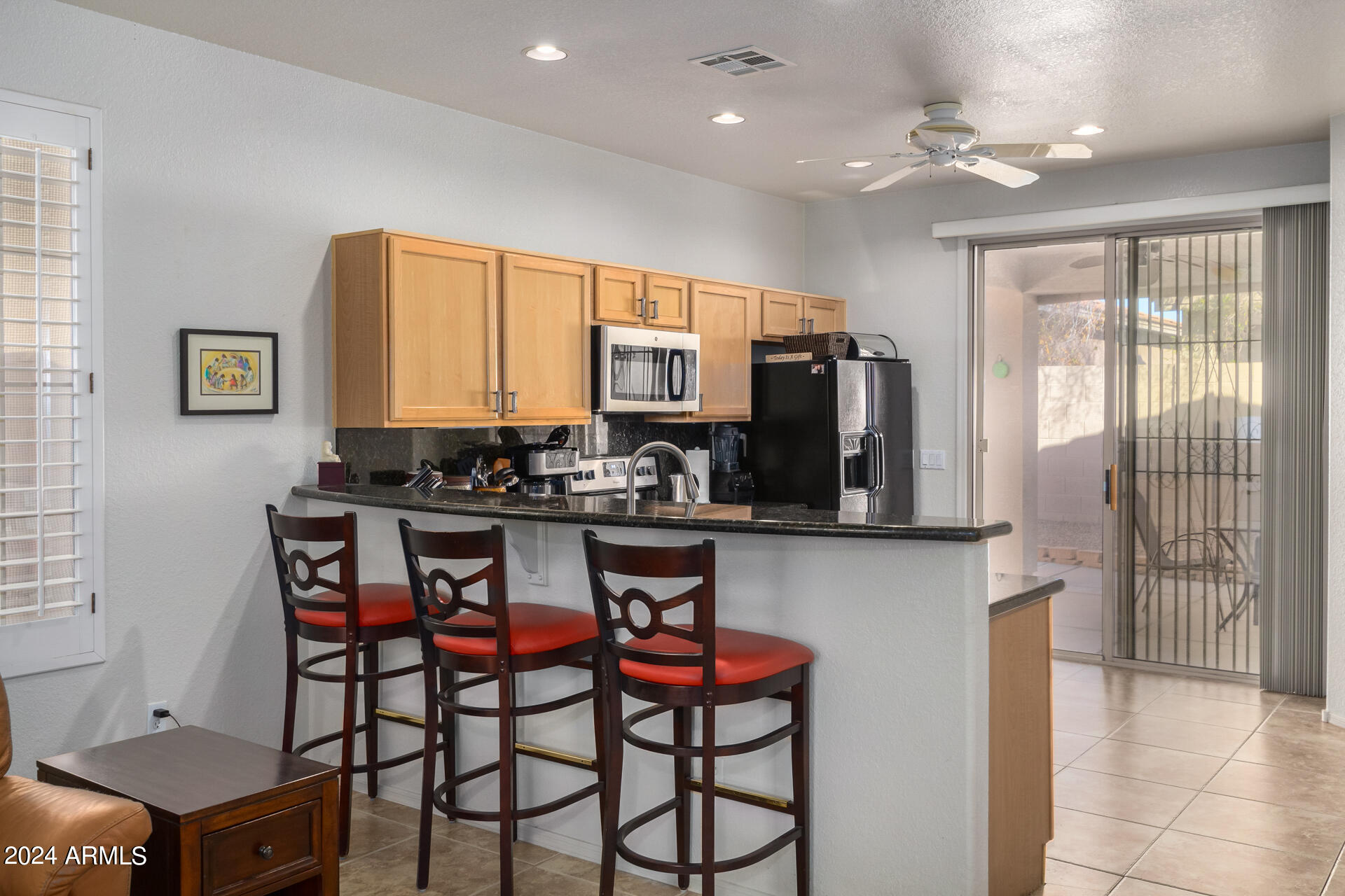 2063 South Edgewater Mesa, AZ 85209 - Photo 9 of 35 a kitchen with stainless steel appliances granite countertop a stove a sink a refrigerator cabinets and a dining table with chairs