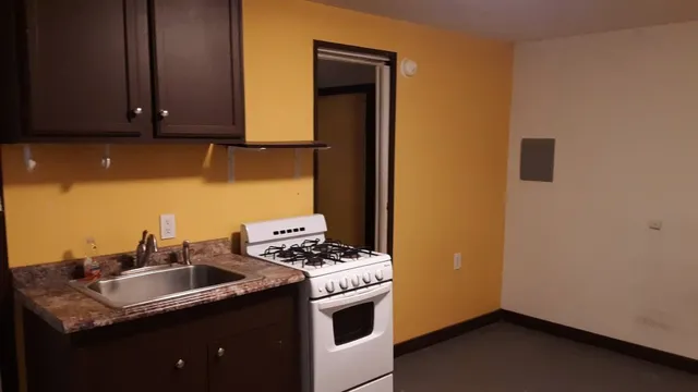 a kitchen with stainless steel appliances granite countertop a sink a stove and a refrigerator