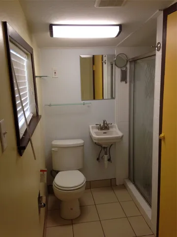 a bathroom with a toilet a sink and mirror