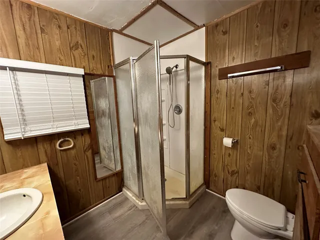 a bathroom with a shower a toilet and a sink