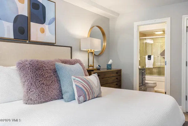 a bedroom with a bed and dresser with mirror