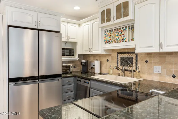 a kitchen with stainless steel appliances granite countertop a refrigerator sink and cabinets