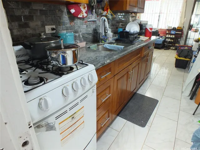 a kitchen with stainless steel appliances granite countertop a sink stove and cabinets
