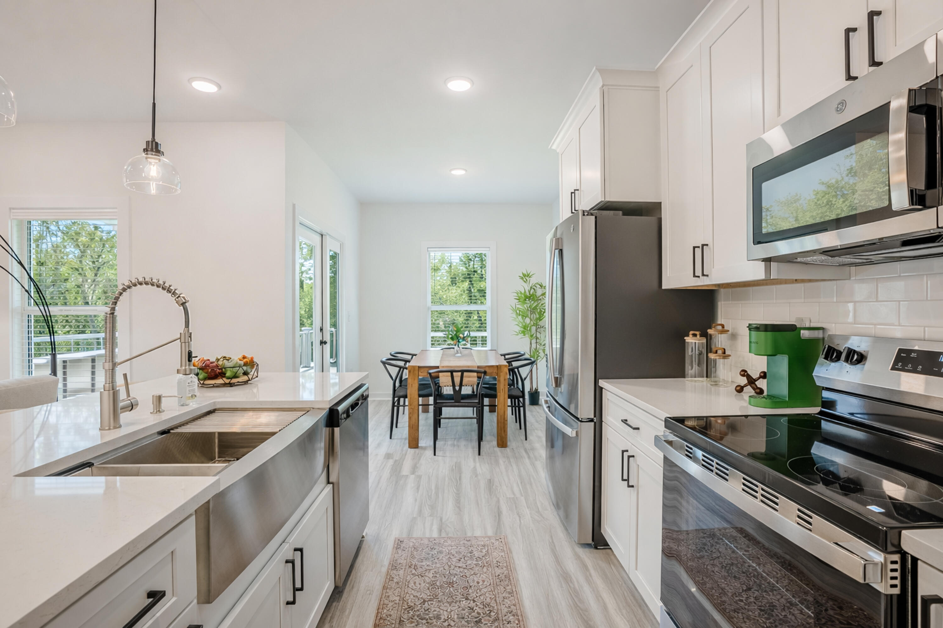2021 Baldwin Street Chipley, FL 32428 - Photo 11 of 35 a kitchen with stainless steel appliances a stove a sink a microwave a refrigerator white cabinets and wooden floor