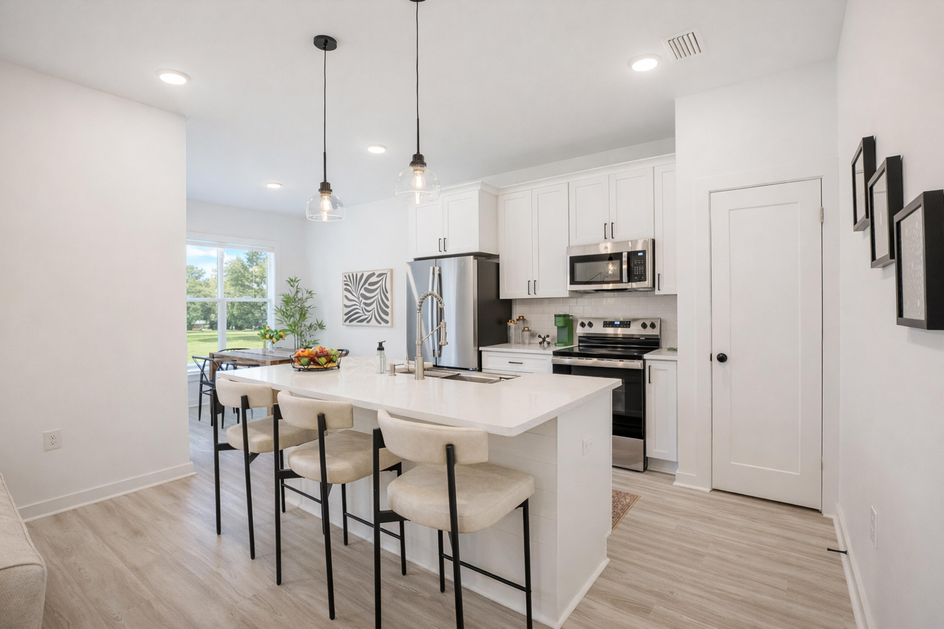 2021 Baldwin Street Chipley, FL 32428 - Photo 8 of 35 a kitchen with stainless steel appliances a dining table chairs refrigerator and microwave