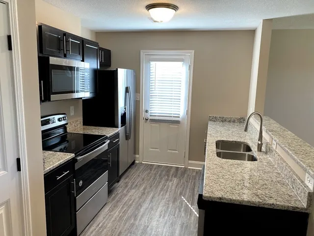 a kitchen with granite countertop stainless steel appliances and wooden cabinets