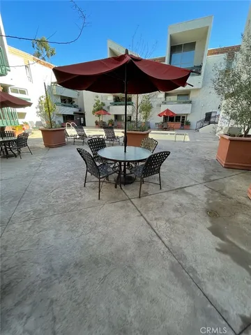 a view of patio with table and chairs under an umbrella
