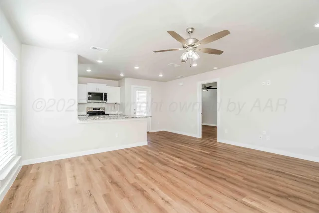 a view of kitchen with kitchen island wooden floor center island and stainless steel appliances
