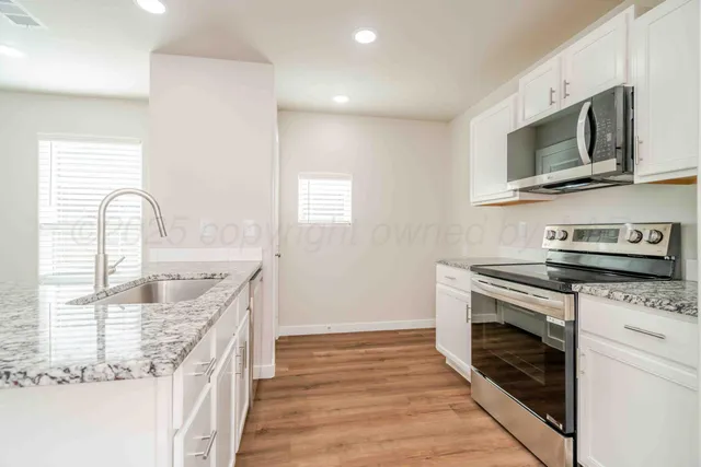 a kitchen with stainless steel appliances granite countertop a sink and a stove top oven
