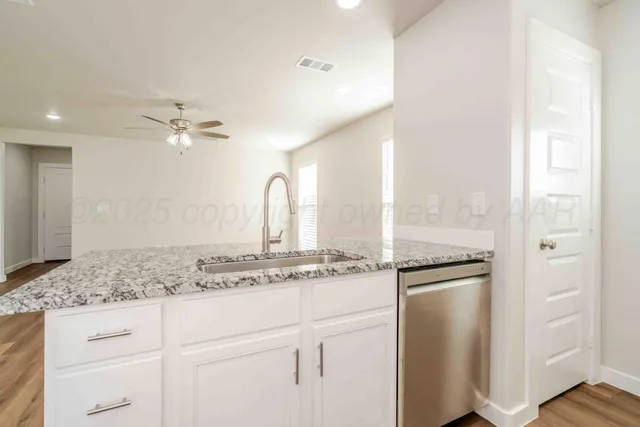 a view of a faucet a sink and a refrigerator