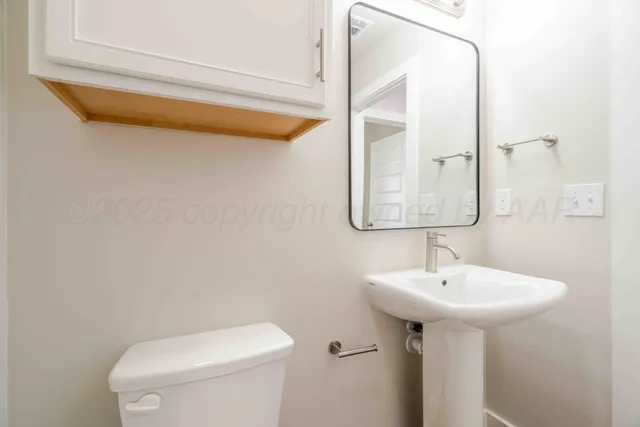 a bathroom with a sink a mirror and toilet