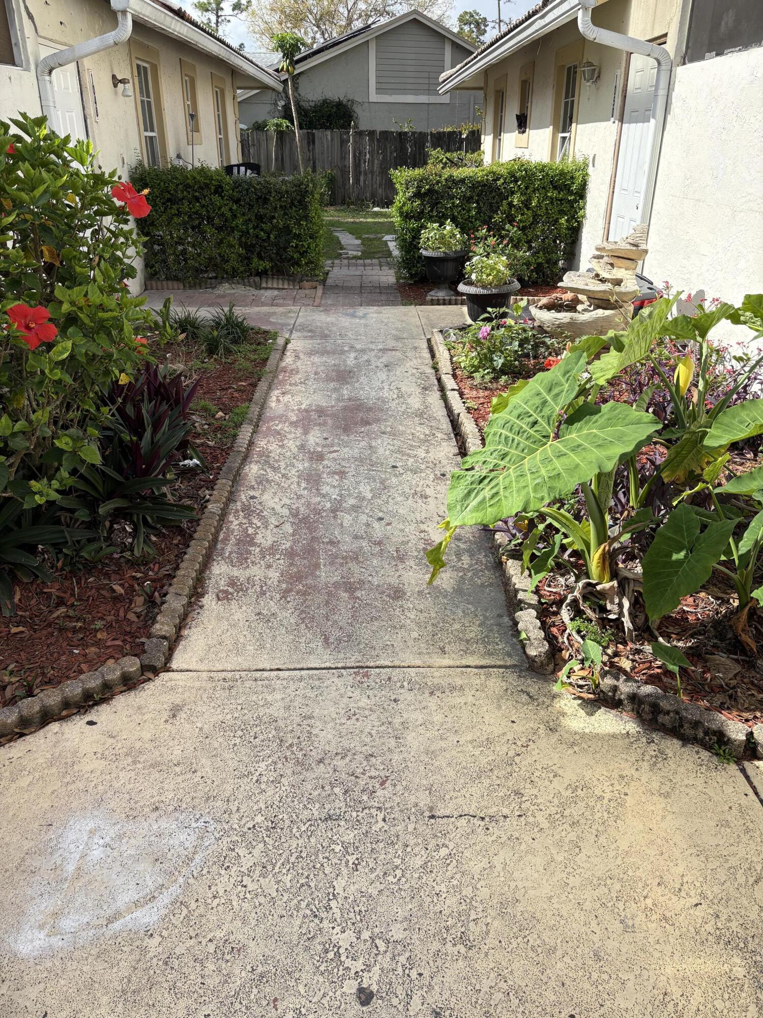 1046 Goldenrod Road, Unit 1048 Wellington, FL 33414 - Photo 3 of 10 a view of a garden with plants and flowers