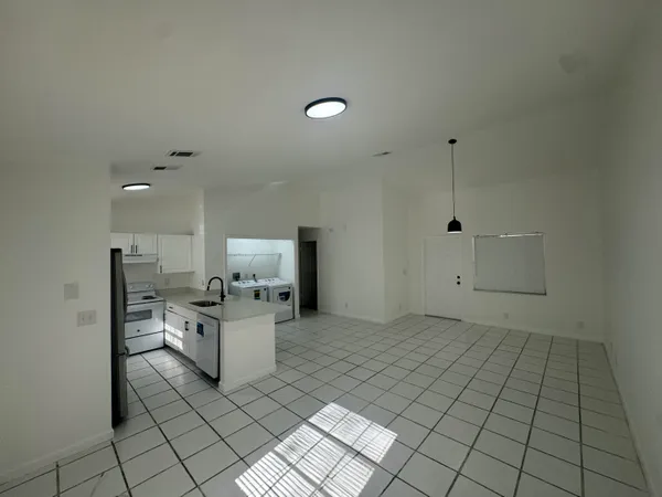 a kitchen with a refrigerator a stove a sink a washer and dryer