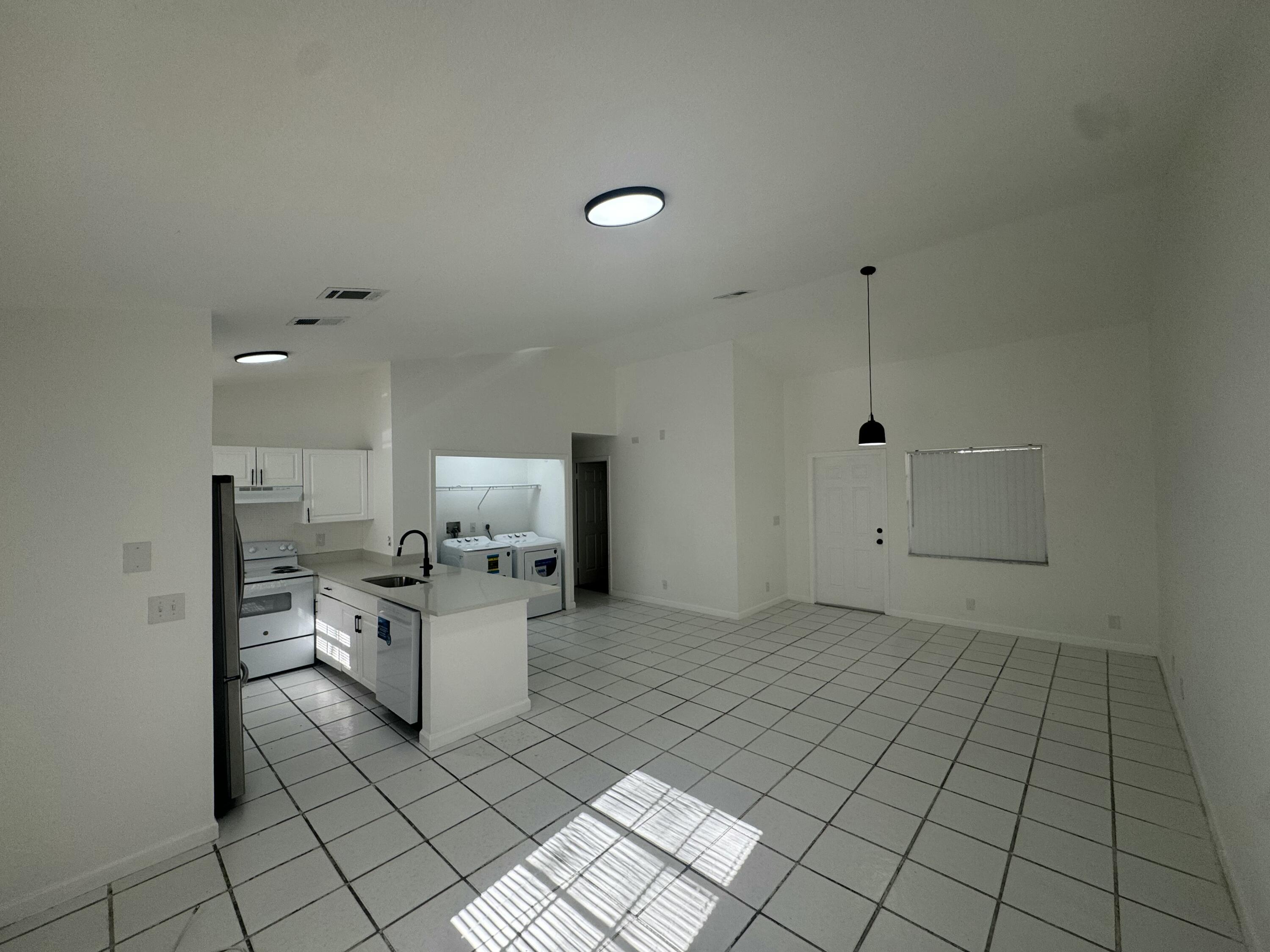 1046 Goldenrod Road, Unit 1048 Wellington, FL 33414 - Photo 5 of 10 a kitchen with a sink and a stove top oven