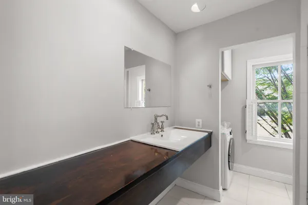 a bathroom with a sink a large mirror and a window
