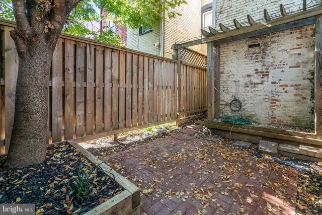 a view of a pathway of a yard with wooden fence