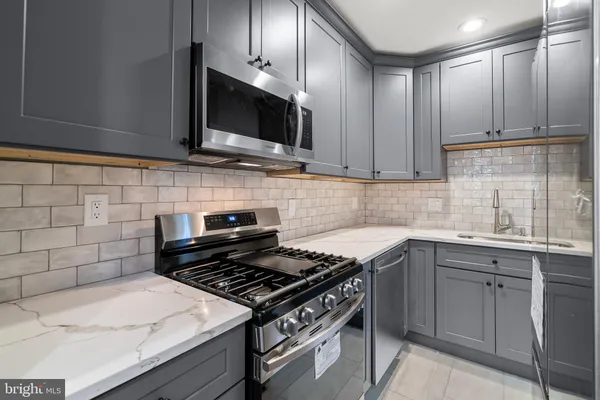 a kitchen with stainless steel appliances a sink a stove and cabinets