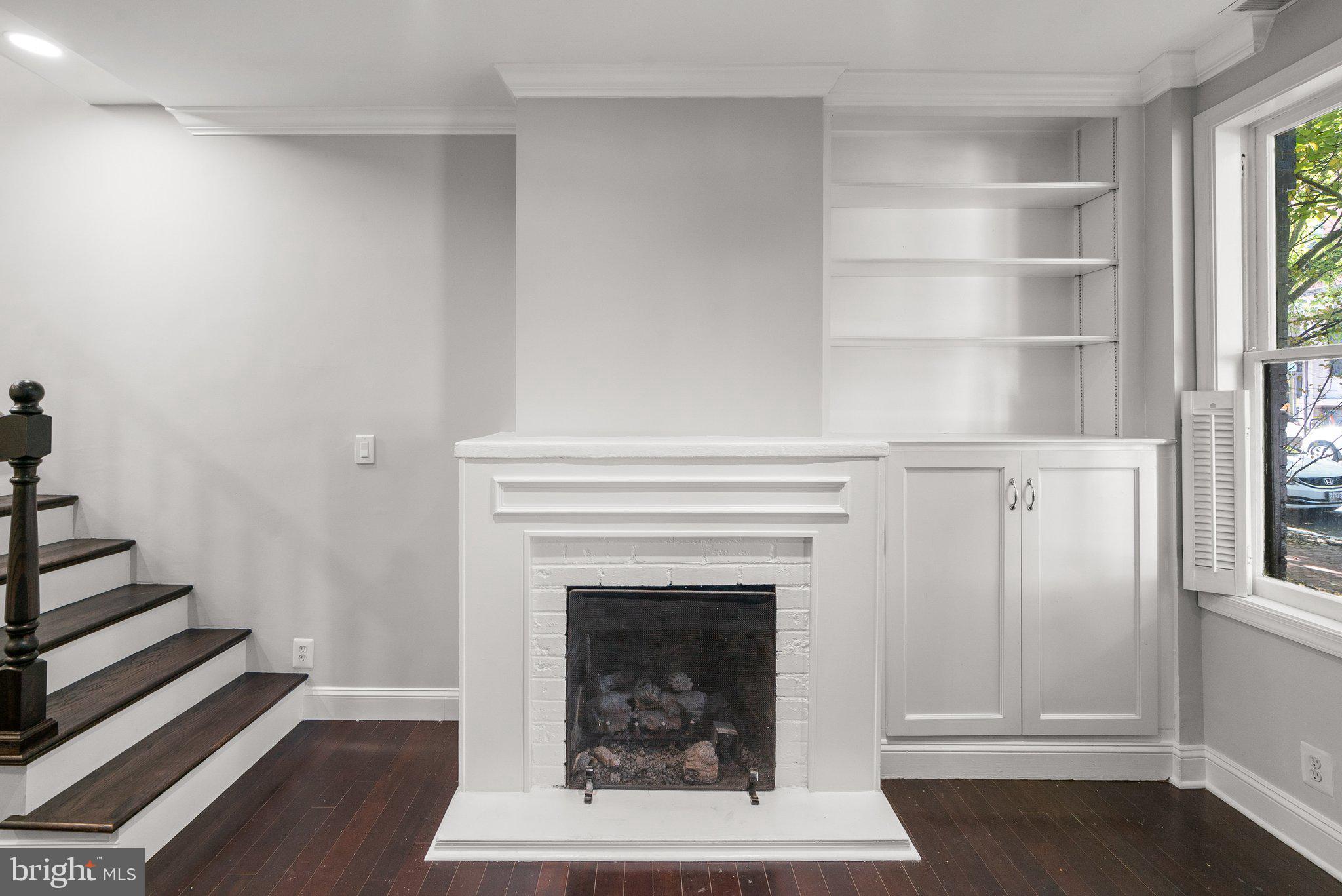 1257 35th Street Northwest Washington, DC 20007 - Photo 10 of 21 a living room with a fireplace and a window
