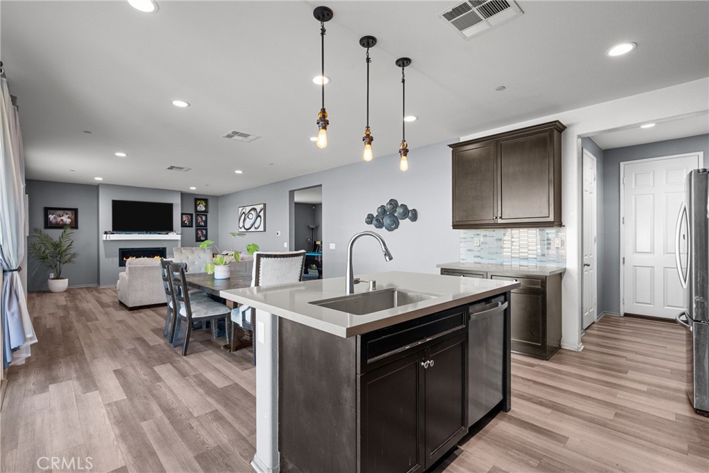 6949 Beale Road Palmdale, CA 93552 - Photo 10 of 32 a kitchen with stainless steel appliances granite countertop a sink stove and wooden floor