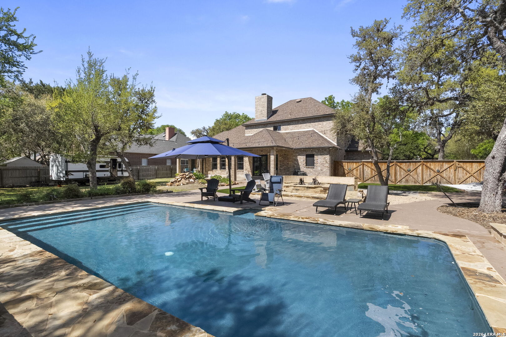 10918 Hunters Way Helotes, TX 78023 - Photo 46 of 49 a view of a swimming pool with lounge chairs in patio