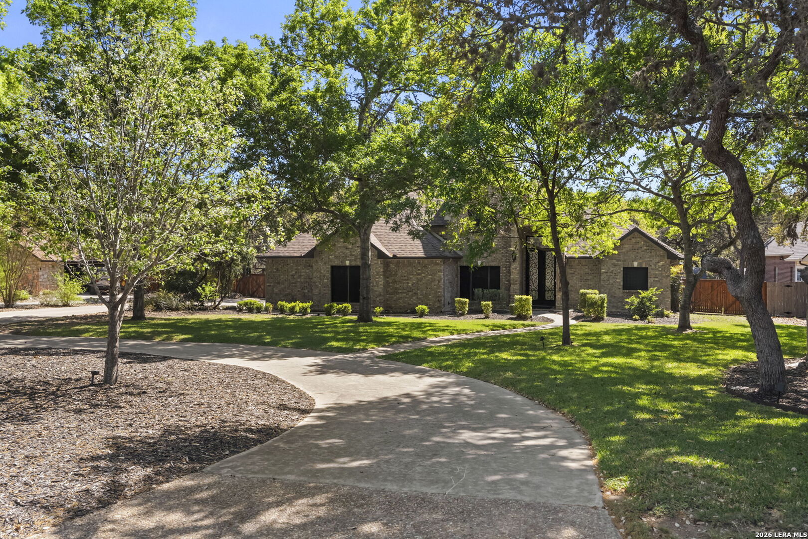 10918 Hunters Way Helotes, TX 78023 - Photo 7 of 49 a front view of a house with a yard and an trees